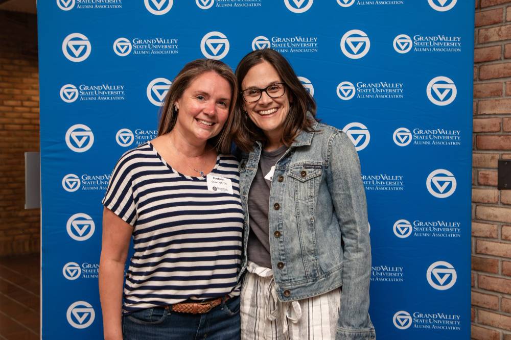 Two alums smiling for a photo together.